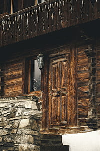 brown wooden house near gray wall thumbnail