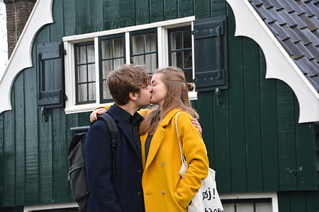 man and woman kissing in front of house thumbnail