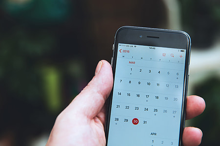 Man checking the calendar app on his iPhone mobile smartphone thumbnail