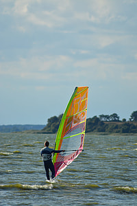 man in white and black wetsuit riding on windsurf on sea during daytime thumbnail