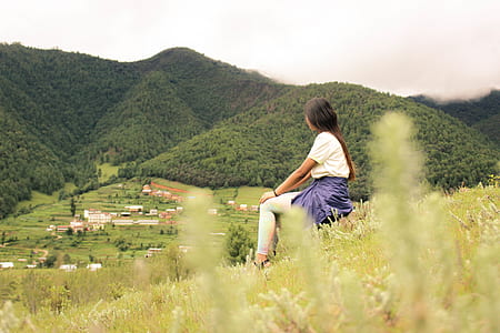 woman sitting on grass during daytime thumbnail
