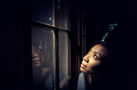 woman looking up in the sky in front of glass window during nighttime low light photography thumbnail