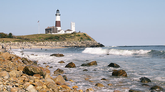 brown and white lighthouse near body of water thumbnail