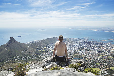 man sitting on rock formations thumbnail