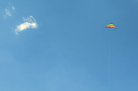 multicolored kite hoovering on clear sky thumbnail