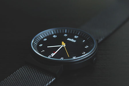 round black analog watch reading at 7:30 in tilt shift photography thumbnail