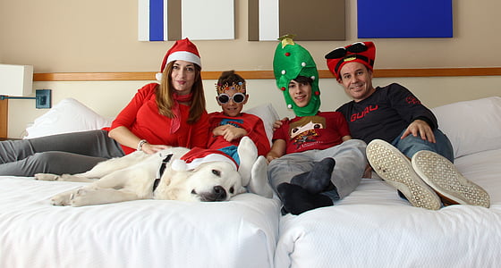 family and white Labrador sitting on bed inside the room thumbnail