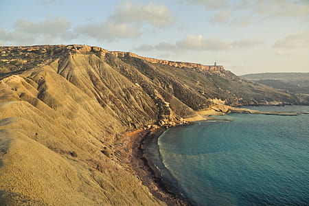 Side view of Golden Bay Mellieha Malta with torquoise blue water and rocks thumbnail