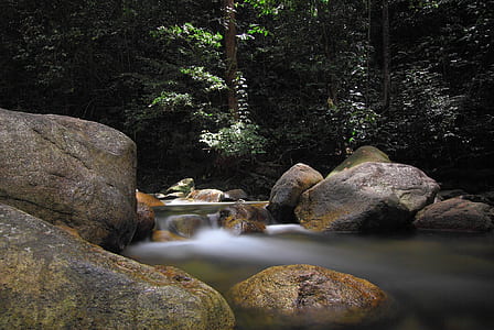 time lapse photography of river surrounded with rocks and trees thumbnail