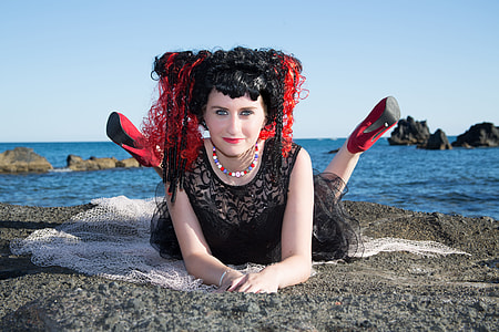 woman lying on rock near sea thumbnail