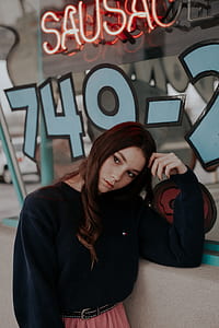 woman wearing black Tommy Hilfiger crew-neck sweater leaning its hand on wall thumbnail