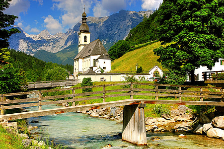concrete bridge surrounded with trees and white cathedral in distance thumbnail