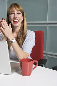 woman seats on red chair with red mug on table thumbnail