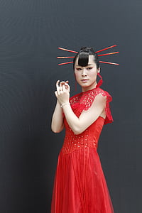 woman wearing red cap-sleeved dress with hair sticks thumbnail