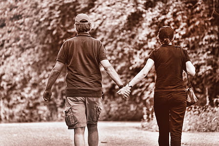 man and woman walking while holding hands thumbnail