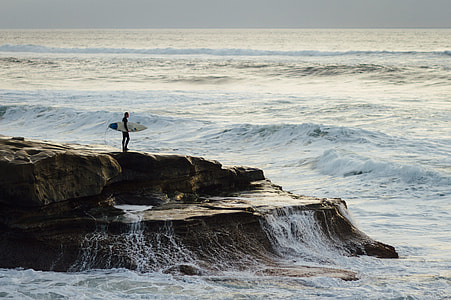 person standing in island holding white surfboard thumbnail