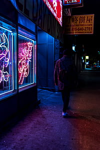 man walking beside building during nighttime thumbnail