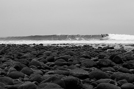 grayscale photography of rocks in seashore thumbnail