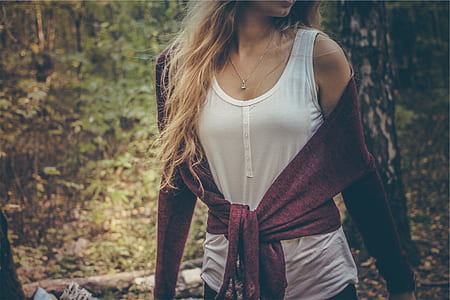 woman wearing white tank top and red sweater on forest thumbnail