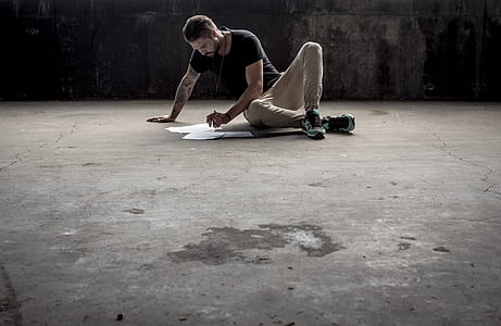 man sitting on ground while making artwork thumbnail