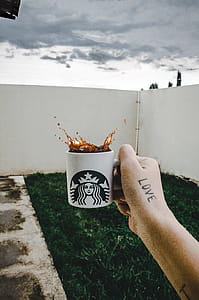 Person Holding Starbucks Cup With Brown Beverage thumbnail