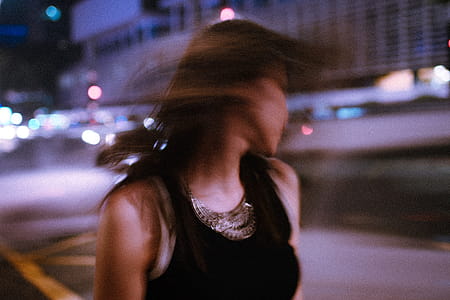 Tilt Shift Photography of Woman Wearing Tank Top during Nighttime thumbnail
