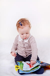 baby holding white and green garment thumbnail