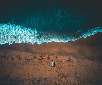 man lying on seashore aerial photography thumbnail
