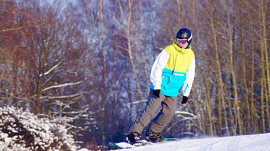 person snowboarding near pine trees thumbnail