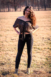 woman in black off-shoulder crop top and black leggings standing on dried grass field thumbnail