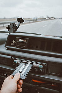 person holding cassette tape in 1-DIN head stereo thumbnail