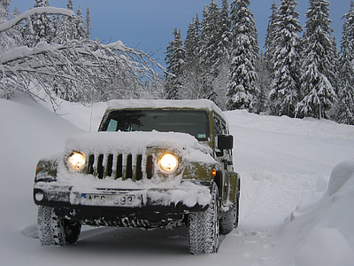 green Jeep Wrangler on snowfield near trees thumbnail