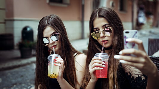 two woman sipping while taking selfie at daytime thumbnail