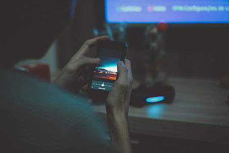 person siting near table using smartphone thumbnail