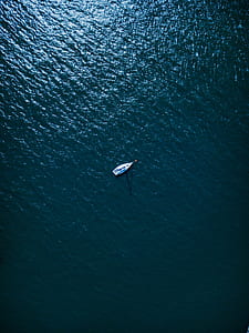 white boat in the middle of the sea during daytime thumbnail