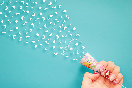 person holding white, pink, and blue Congratulations party popper thumbnail