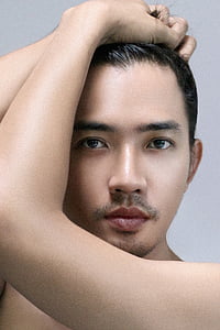 close-up photo of man standing near white painted wall thumbnail