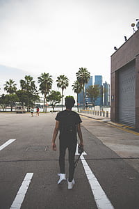 man holding camera standing on road thumbnail