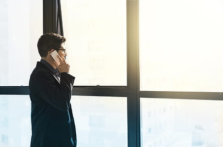 man talking on the phone while looking out the window thumbnail