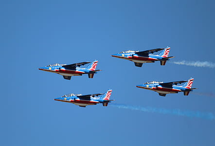 four blue-and-red jet planes in mid air during daytime thumbnail