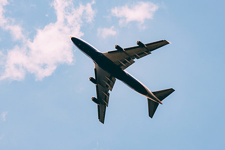 gliding airplane under blue and white cloudy skies at daytime thumbnail