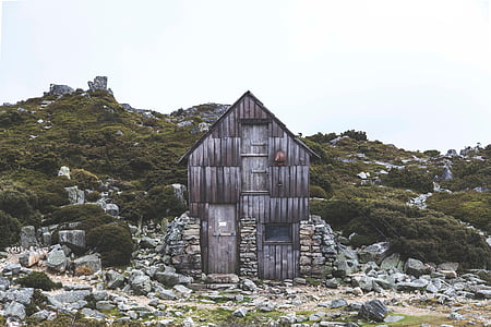 gray wooden house near mountain thumbnail