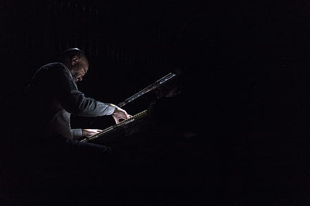 person sitting on chair while playing piano thumbnail