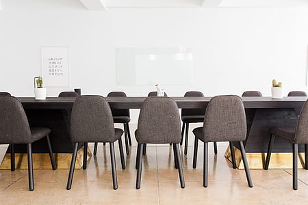 black armless chairs facing black wooden conference table thumbnail