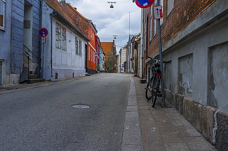bicycle parked on post overlooking empty road at daytime thumbnail
