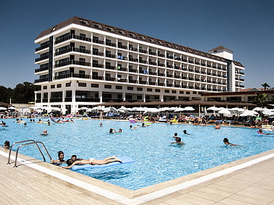 people bathing in swimming pool near concrete building thumbnail