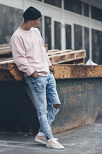 man leaning on orange metal container near building thumbnail