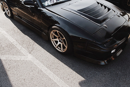 black sports coupe parked on pavement thumbnail