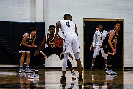 man holding basketball looking right in basketball court thumbnail