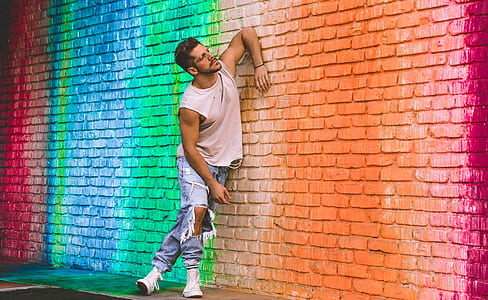man leaning on orange, green, and blue wall thumbnail